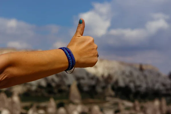 Thumbs up of women hand with Cappadocia, Turkey on background. Picture with shallow depth of field