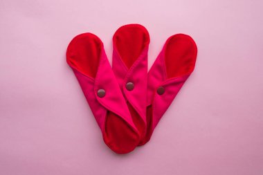 Reusable Cloth Sanitary Menstrual Pads. Flat lay top view on pink background. Zero waste concept. Caring for the environment. Women Health. Conscious consumption. Alternative to disposable pads. clipart
