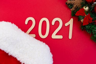 2021 numaralı film, yeni yıl şapkasının kırmızı arka planında yer alıyor. Noel ağacının süslemeli bir dalının yanında. Üst görünüm alanın derinliği