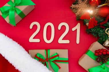 2021 numaralı film, yeni yıl şapkasının kırmızı arka planında yer alıyor. Bir Noel ağacının dalına yakın ve hediyelerle süslenmiş. Üst görünüm alanın derinliği