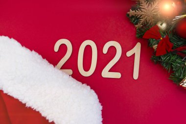 2021 numaralı film, yeni yıl şapkasının kırmızı arka planında yer alıyor. Noel ağacının süslemeli bir dalının yanında. Üst görünüm alanın derinliği