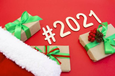 2021 numaralı film, yeni yıl şapkasının kırmızı arka planında yer alıyor. Yakındaki hediyeler süslemelerle paketlenmiş. Üst görünüm alanın derinliği