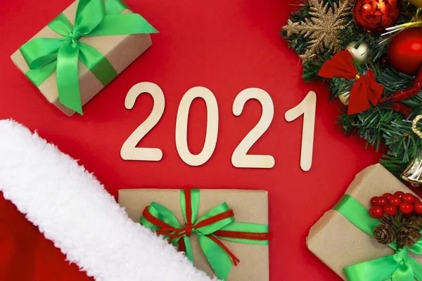 Фанера 2021 Года Лежит Красном Фоне Новогодней Шляпе Рядом Ветка — стоковое фото