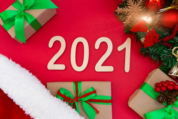 Plywood Čísla 2021 Leží Červeném Pozadí Novoroční Klobouk Nedaleko Větve — Stock fotografie