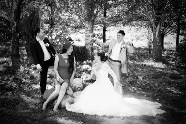 güzel gelin ve damat arkadaşlarıyla parkta yürüyüş