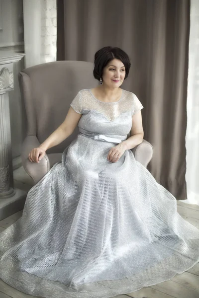 Beautiful aged asian woman in silver dress