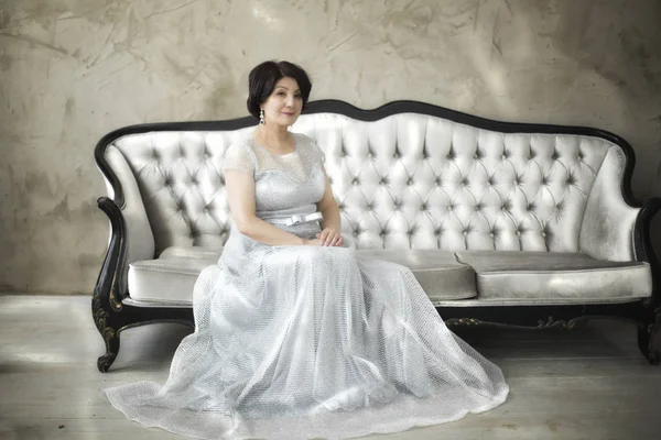 Beautiful aged asian woman in silver dress