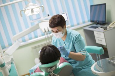 Diş doktoru klinikte manipülasyon yapıyor. Kadın