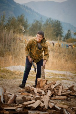 Asyalı adam odun kesiyor. Yerde odun