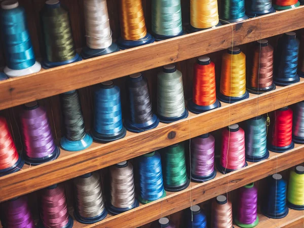 Bobine colorate su scaffale Tessuto tessile filo intrecciato — Foto Stock