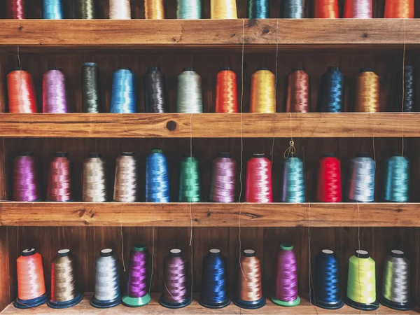 Colourfuls bobbins på hyllan väver tråd textil tyg — Stockfoto