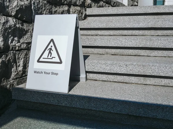 Watch your step Caution sign on stair step Building outdoor sign — Stock Photo, Image