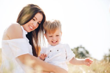 Mutlu ebeveynlik kavramı. Genç anne ve onu Kızıl saçlı, iki yaşında oğlu harcama zaman güneşli bir günde açık.