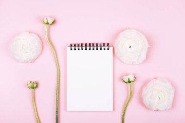 Defter üzerinde pastel pembe güzel bahar Düğünçiçeği çiçekli temiz sayfa ile. Üstten görünüm. Düz yatıyordu stili.