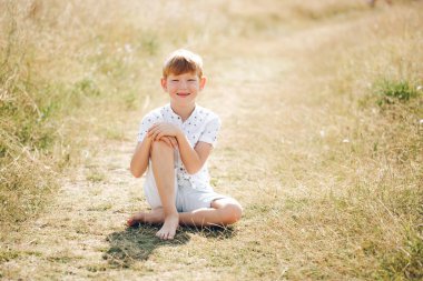 gülümseyen güneşli çim Kızıl saçlı mutlu çocuk portresi 