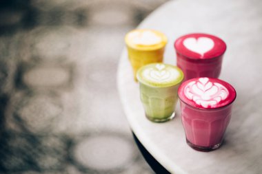 trendy multicolored lattes, beetroot, avocado and turmeric tastes with latte art clipart