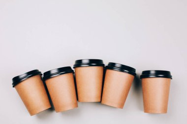 birçok kahverengi zanaat bardak kahve gri arka plan üzerinde düz gitmek yatıyordu 