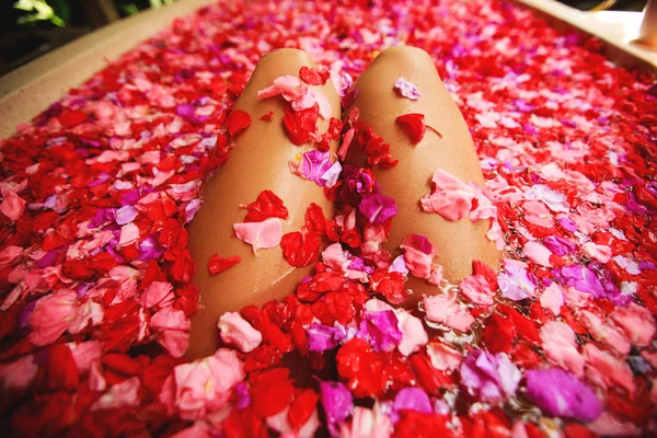 Woman in bath with petals. — Stock Photo, Image