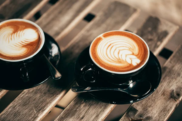 iki siyah fincan cappuccino latte art ahşap masa Tarih ile