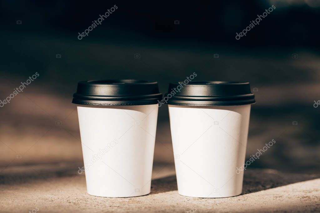 two white craft cups of coffee to go closeup 