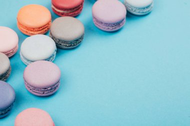 Pastel renkli macarons trendy arka plan üzerinde grup.