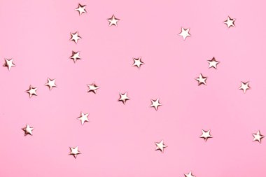 Pembe arka planda altın yıldızlar parıldıyor. Bayram pastel arka planı.