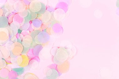 Pastel pembe bir arka plan üzerinde canlı konfeti