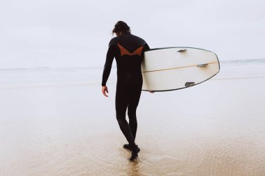 Okyanusa sörfçü surfboard ile gider