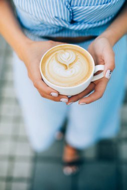 Fincan cappuccino latte sanat ile tutan kadın