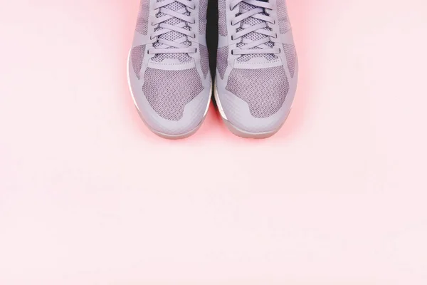 Серые кроссовки на розовом фоне — стоковое фото