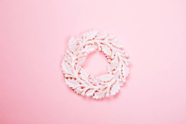Pastel pembe üzerinde Noel dekoratif beyaz çelenk.