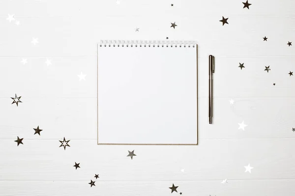 Cuadrado blanco en forma de cuaderno con pluma sobre fondo de madera pastel . — Foto de Stock