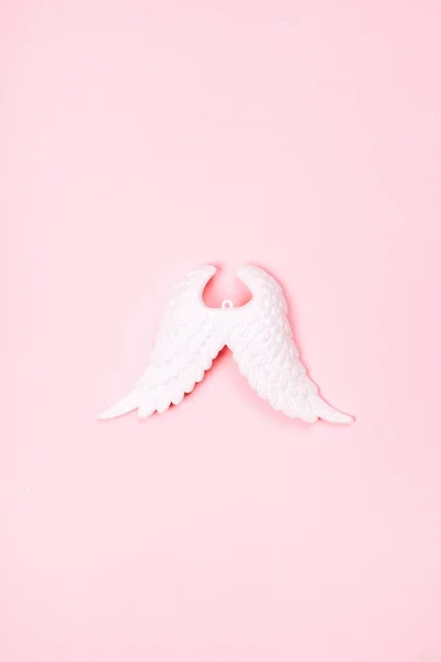 Christmas decorative white sparkling wings of angel on pink pastel background. — Stock Photo, Image