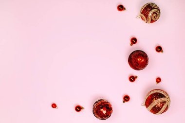 Kırmızı Noel topları çerçeve pastel pembe oluşturuyorsunuz. Metin için yer. Festival kavramı.