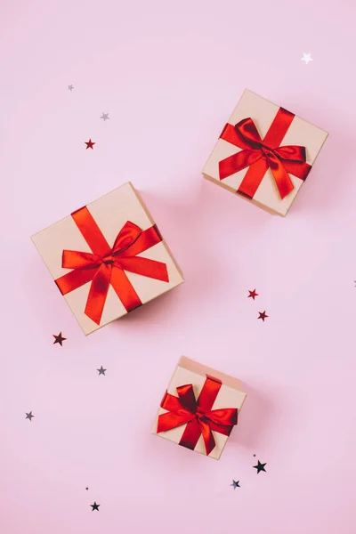 Three presents with red bow on pink