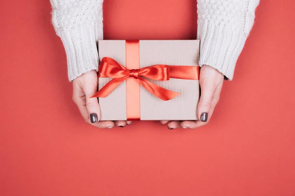 礼物盒与弓在女人的手中 活珊瑚 2019年的颜色 — 图库照片