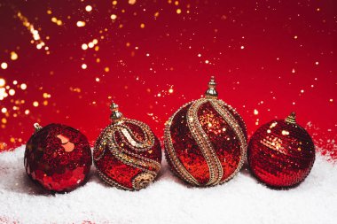 Dört Noel dekoratif topları kar siyah zemin üzerine dokulu.