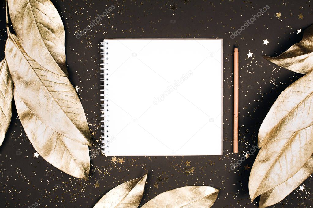 Goal list for New Year. top view of holiday decorations and notebook with blank page on dark table