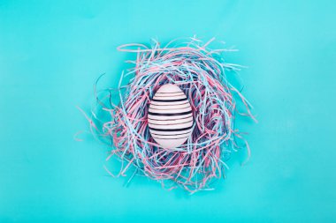 Mavi Pastel arka planda dekoratif yuvada çizgi yumurta el boyalı grafik.