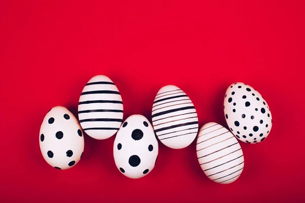 Diferentes gráficos pintados à mão ovos no fundo vermelho brilhante . — Fotografia de Stock