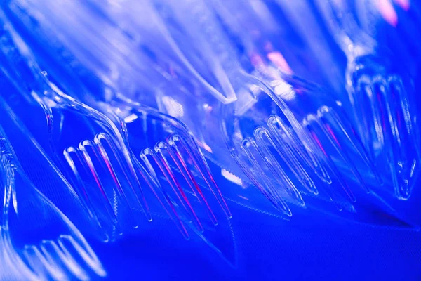 Mor neon ışıkta plastik şeffaf çatal bıçak takımı.