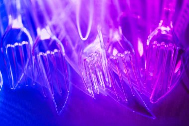 Mor neon ışıkta plastik şeffaf çatal bıçak takımı.