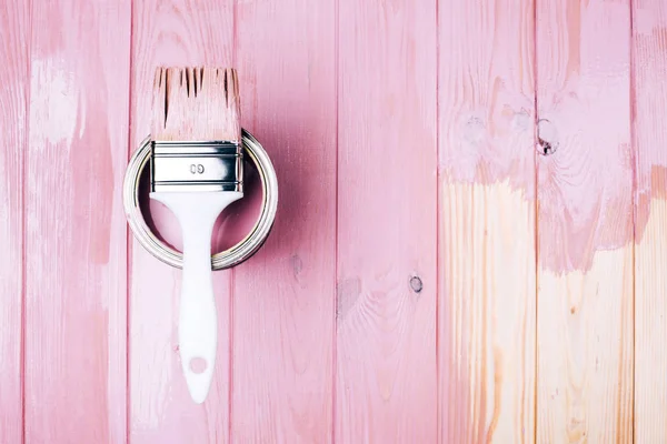 Белая кисть на открытой банке розового цвета на деревянной доске . — стоковое фото