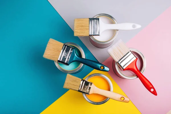 Four open cans with brushes on them on bright symmetry background. — Stock Photo, Image