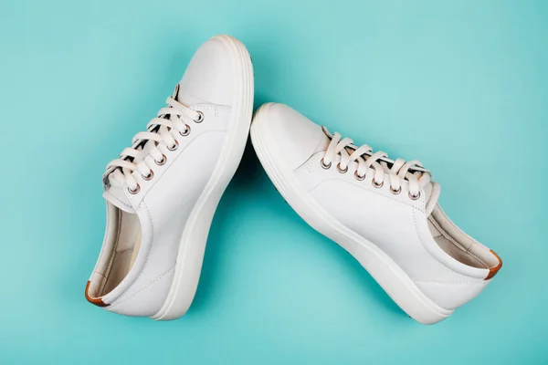 White trendy sneakers on turquoise background. — Stock Photo, Image