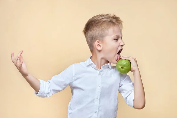 Şirin, dağınık çocuk kendini şımartıyor ve ellerindeki armudu yalıyor..