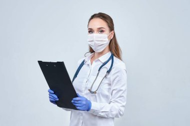 Gözlüklü genç çekici doktor steteskop kullanarak nefes alışını dinliyor. Tıbbi konsept.