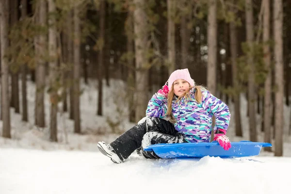 自信的女孩坐在她的雪橇上山 — 图库照片
