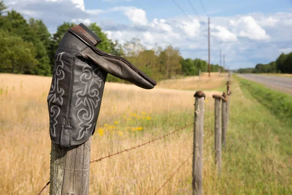 Cowboy boot på staketstolpe — Stockfoto