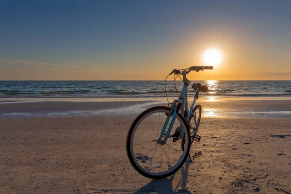 Vélo sur une plage au coucher du soleil — Photo